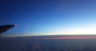 帰路の機窓から見た雲間の夕焼け